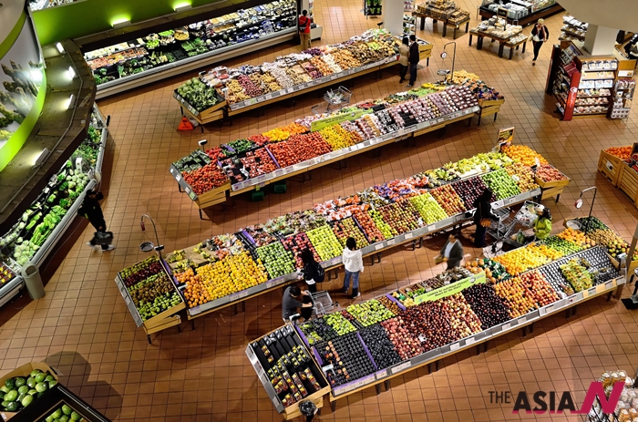 슈퍼마켓에서 과일을 고르고 있는 사람들의 모습