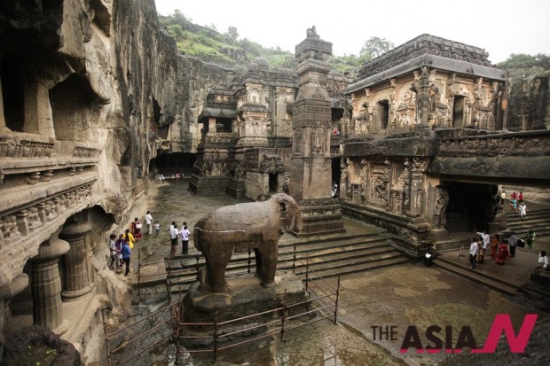 (140806) -- MAHARASHTRA, Aug. 6, 2014 (Xinhua) -- Tourists visit the stone Jain temple at the ellora caves near Aurangabad in Maharashtra, India, Aug. 6, 2014. The 34 monasteries and temples, extending over more than 2 km, were dug side by side in the wall of a high basalt cliff, not far from Aurangabad, in Maharashtra. Ellora, with its uninterrupted sequence of monuments dating from A.D. 600 to 1000, brings the civilization of ancient India to life. Not only is the Ellora complex a unique artistic creation and a technological exploitation but, with its sanctuaries devoted to Buddhism, Hinduism and Jainism, it illustrates the spirit of tolerance that was characteristic of ancient India. (Xinhua/Zheng Huansong)