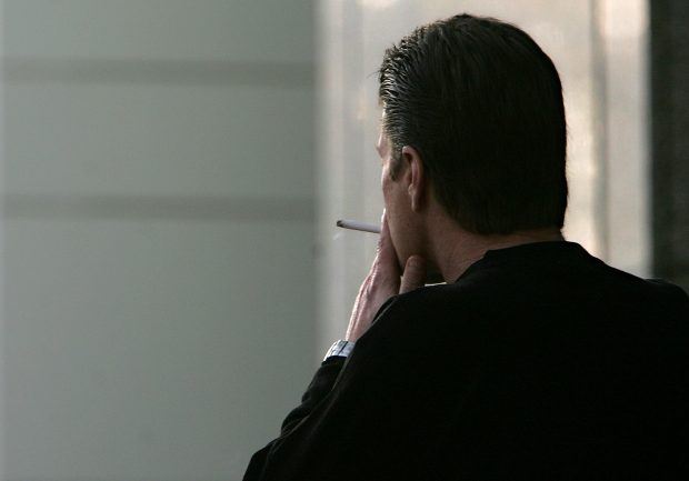 FILE - In this Dec. 13, 2005, file photo, an unidentified man smokes a cigarette in Sacramento, Calif. The adult smoking rate fell in 2015, with its largest annual decline in at least 20 years, according to a new government report. (AP Photo/Rich Pedroncelli, File)